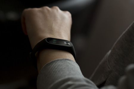 Close-up shot of black fitness tracking band on female hand.の写真素材