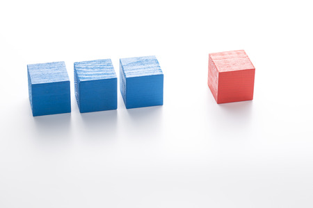 Three blue wooden cubes and red one. Individuality concept.の写真素材