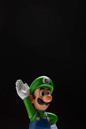 Moscow, Russia - September 24, 2021: Plastic figure of Luigi from Nintendo video game isolated on black background.のeditorial素材