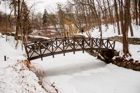 Bridge across frozen river in park Sofievka (Uman, Ukraine)の写真素材