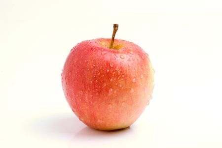 Fresh snack apple on isolated white background for other fruit. Organic, healthy red delicious apple has drops of water on it, stem and slight shadow.の写真素材