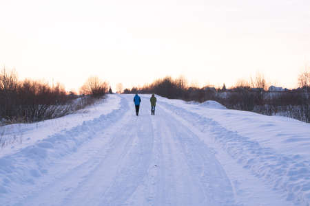 Two people walking on an empty winter roadのeditorial素材