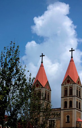 The Catholic Church under the blue sky and white clouds.の写真素材