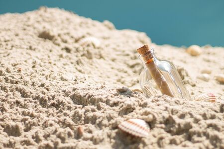 bottle with a letter in the sand on the beachの写真素材