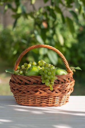 basket with grapes and applesの写真素材