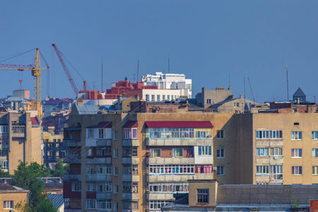 City landscape. Old multi-storey houses and modern buildings against the blue sky. Roofs of...