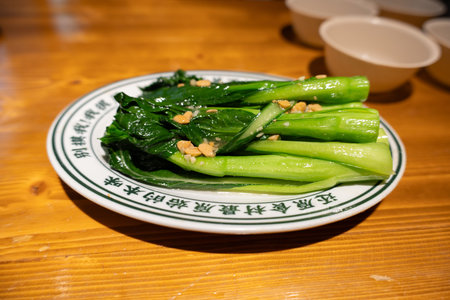 Steamed broccoli with garlic on ceramic plate served on wooden tableの写真素材