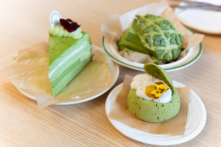 Green Matcha Desserts on Wooden Table with Paper Liners and Floral Garnish
