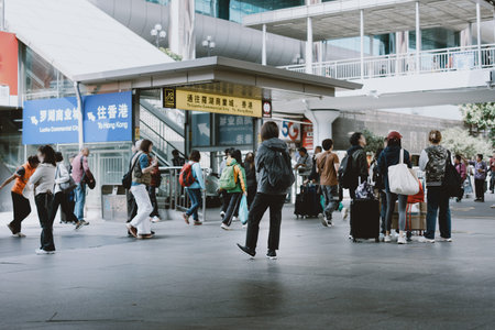 People walking with luggage at busy transportation hub under modern architecture