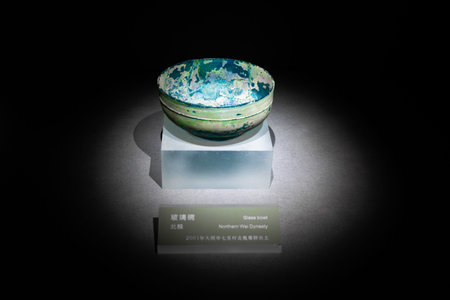 Ancient Chinese Bowl with Blue Glaze Displayed in Museum Under Spotlight