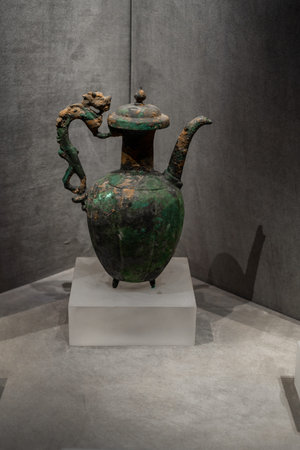 Ancient Chinese bronze teapot with dragon handle displayed in museumの写真素材