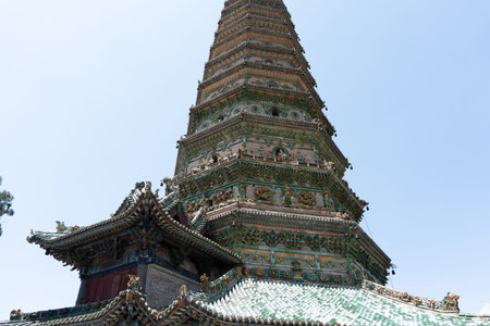 Ancient Chinese Pagoda with Colorful Tiles and Intricate Carvings Under Clear Sky