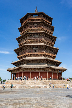Ancient Chinese Pagoda with Wooden Structure Under Blue Sky, Tourists Visiting Historic Architecture