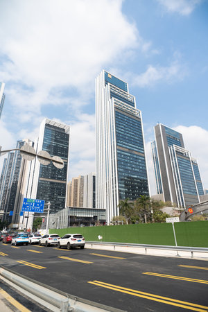 Modern skyscrapers in urban cityscape with cars on road under cloudy sky
