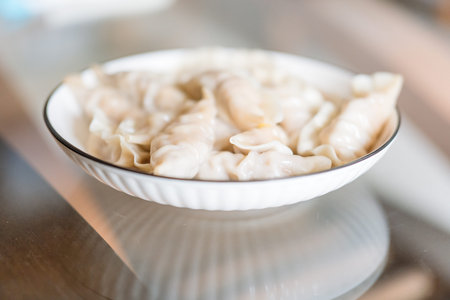 Chinese Dumplings in White Bowl on Glass Table, Steaming Hot Food, Traditional Asian Cuisine, Close-up Food Photographyの写真素材