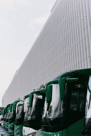 Green buses parked in front of modern building in Shanghai, China