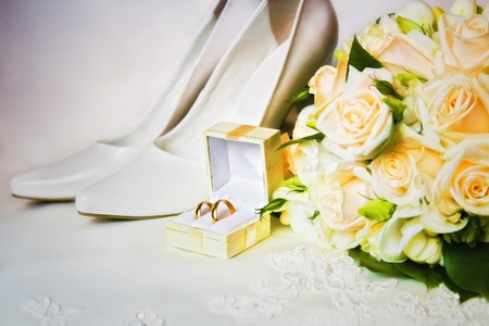 wedding rings in a box with bouquet and high heel shoesの写真素材