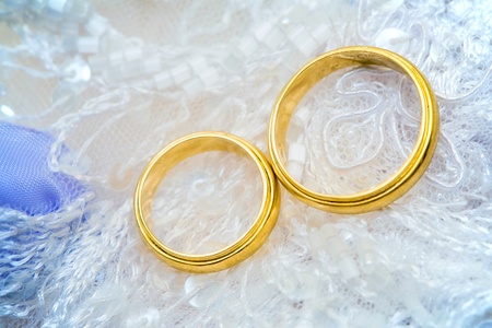 golden wedding rings on laceの写真素材