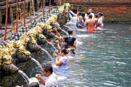 TAMPAK SIRING, BALI, INDONESIA - OCTOBER 30: People praying at holy spring water temple Puru Tirtha Empul during purification ceremony on October 30, 2011 in Tampak Siring, Bali, Indonesiaのeditorial素材
