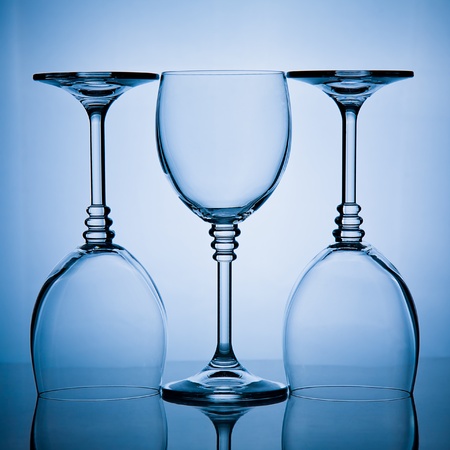 blue toned shot of a  three wineglasses in a rowの写真素材