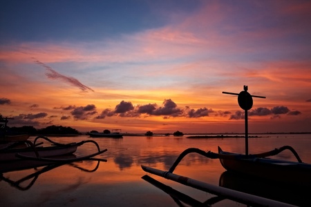 sunset over traditional fishing boats on Baliの写真素材