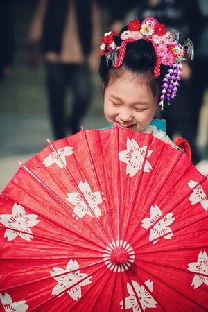 TOKYO, JAPAN - NOVEMBER 28, 2018: Japanese girl with umbrella posing during Shichi-Go-San day at Shinto shrine. Shichi-Go-Sun is annual festival day in Japan for 3, 5 and 7 years old children.のeditorial素材