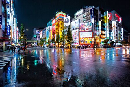 Tokyo, Japan - November 19, 2018: Neon lights and billboard advertisements on buildings at Akihabara at rainy night. Akihabara is a shopping district for video games, anime, manga, and computer goods.のeditorial素材