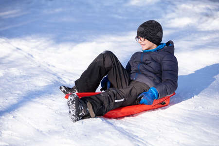 cute little boy sitting on sledの写真素材