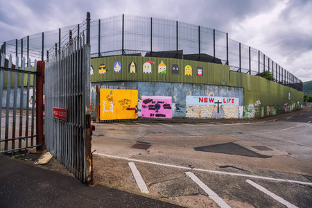 Belfast, Northern Ireland, UK - June 26, 2017: Open metal gate close to Peace Wall on crossroad of North Howard Street and Cupar Way that separate catholics and protestants.のeditorial素材