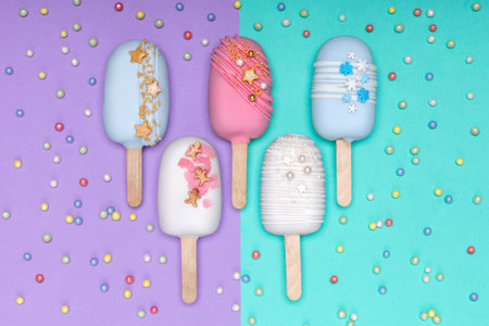 top view of decorated cake pops ice creams on violet and turquoise backgroundの写真素材