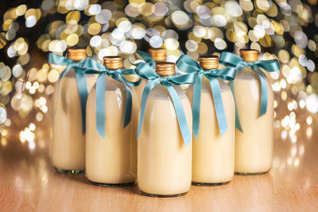 Homemade eggnog in bottles with blue bows on light spotty backgroundの写真素材