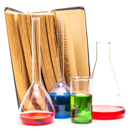 Old books and chemical glassware isolated on whiteの写真素材