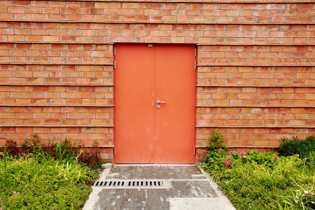 image of orange single door against brick wall  のeditorial素材