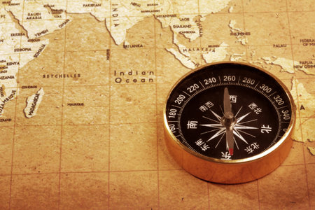 An old brass compass on a Treasure map background 