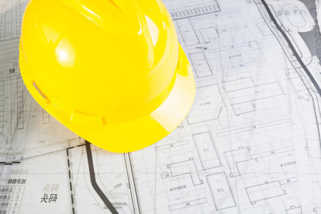 Construction plans with yellow helmet