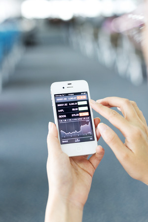 Hangzhou,China-October 6,2014: business passenger use smart phone to check the stock report in airport.のeditorial素材