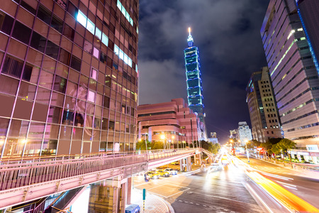 Busy traffic light trails in modern street and illuminated landmark of taipei at nightのeditorial素材