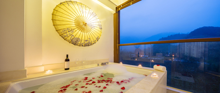 rose floating on water in bathtub of modern bathroom with windowのeditorial素材