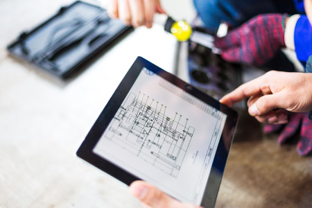 technician holds tablet with mechanical drawingのeditorial素材