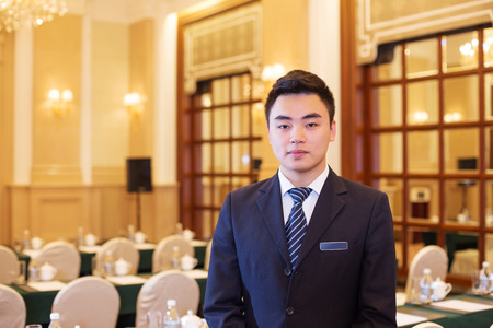 young chinese waiter service in dining roomのeditorial素材