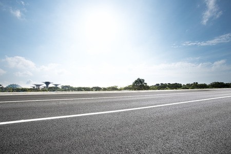 empty road near park with blue sunny skyのeditorial素材