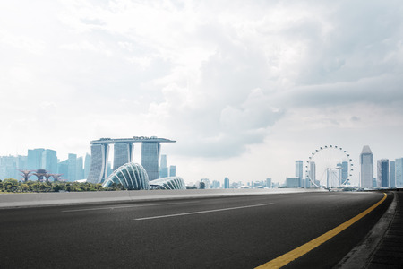 empty asphalt road and cityscape of singapore in cloud skyのeditorial素材