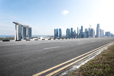 empty asphalt road and cityscape of singapore in cloud skyのeditorial素材