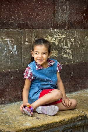 Egyptian girl seated near wall of ancient mosque in Cairo.のeditorial素材