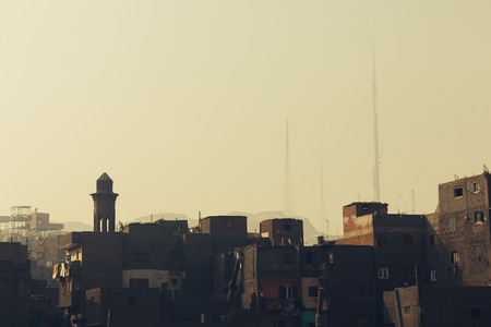 The upper floors of the slums in Cairo with radio towers on hillsの写真素材