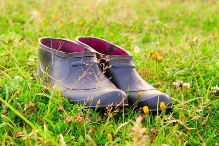 Rubber overshoes stand on a gladeの写真素材