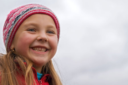 Young girl in a rose cap on a background skyの写真素材