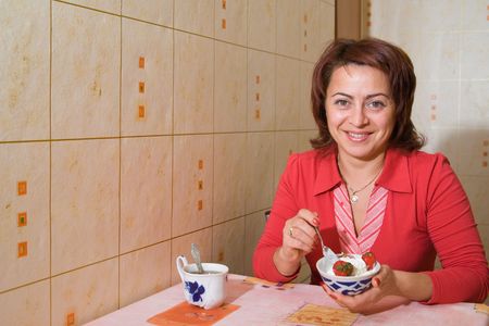 A woman eats an ice-cream with a strawberryの写真素材