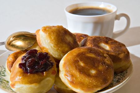 Pancakes lie on a dish. Behind a cup costs with coffeeの写真素材