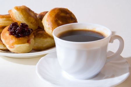 Pancakes lie on a dish. Behind a cup costs with coffeeの写真素材